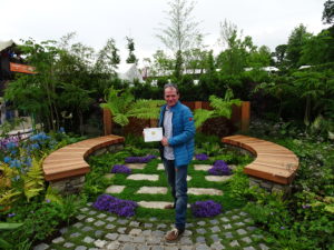 John Durston in his show garden with his gold medal award from Bloom 2017